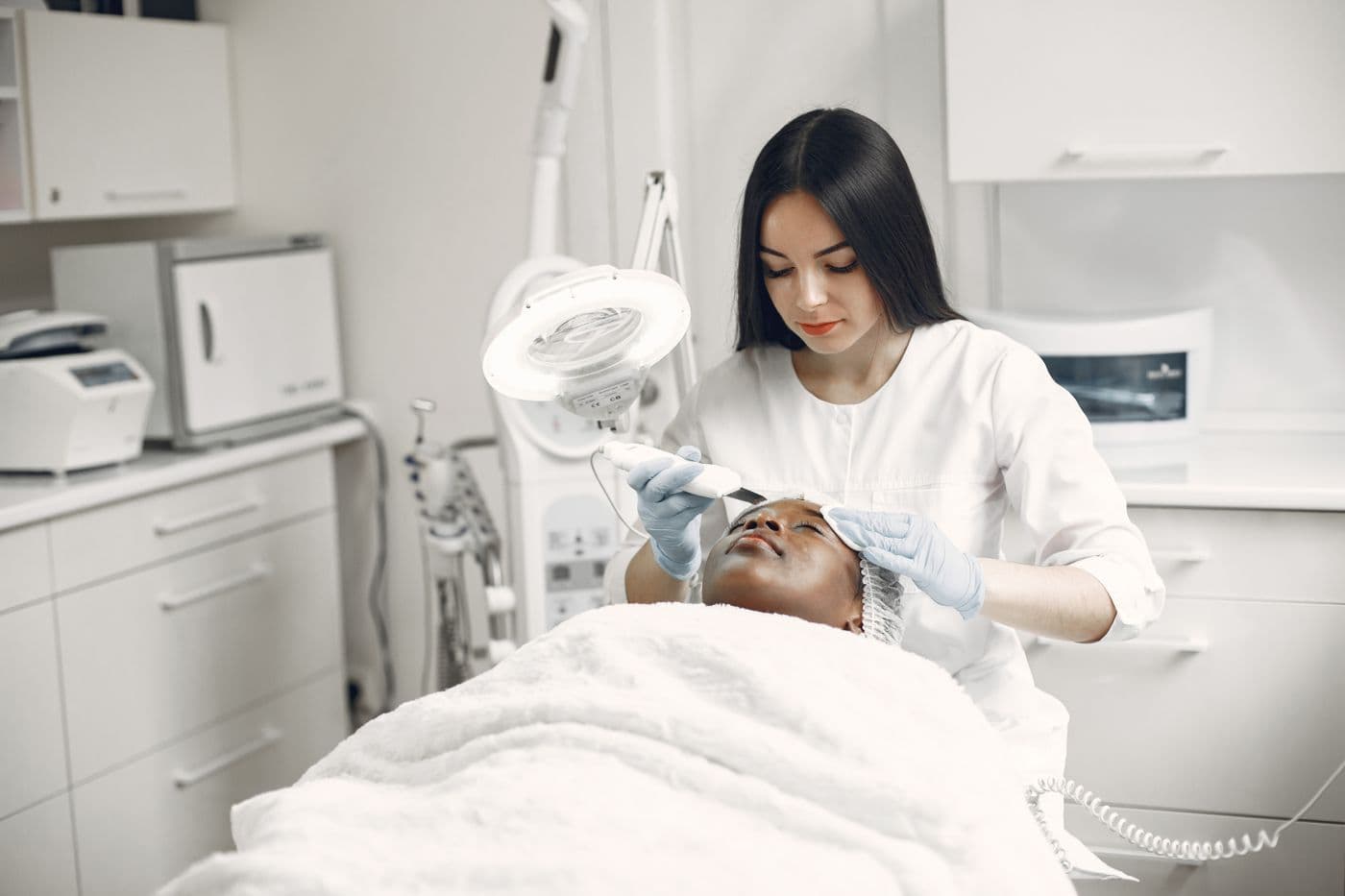 Aesthetic professional delivering a treatment in a modern clinic