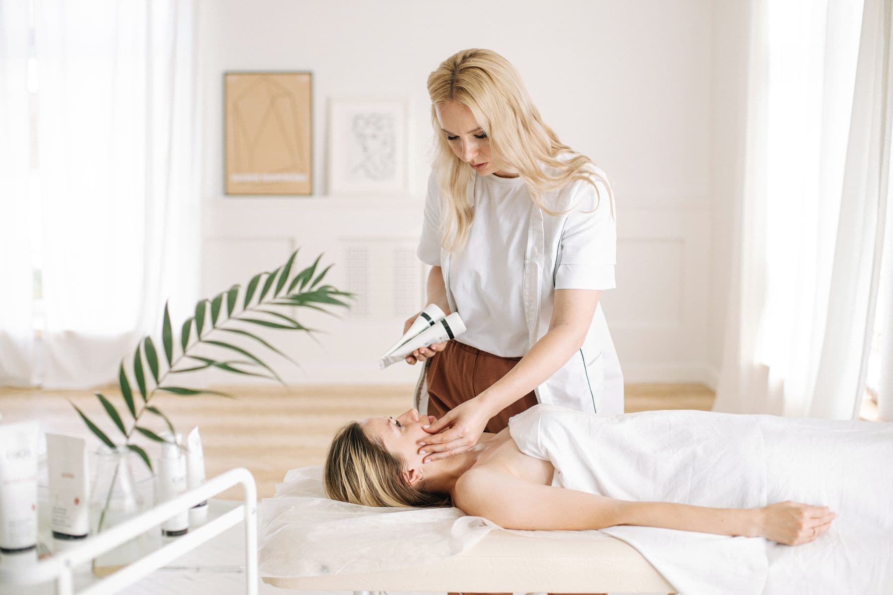 A beauty professional performing a facial treatment
